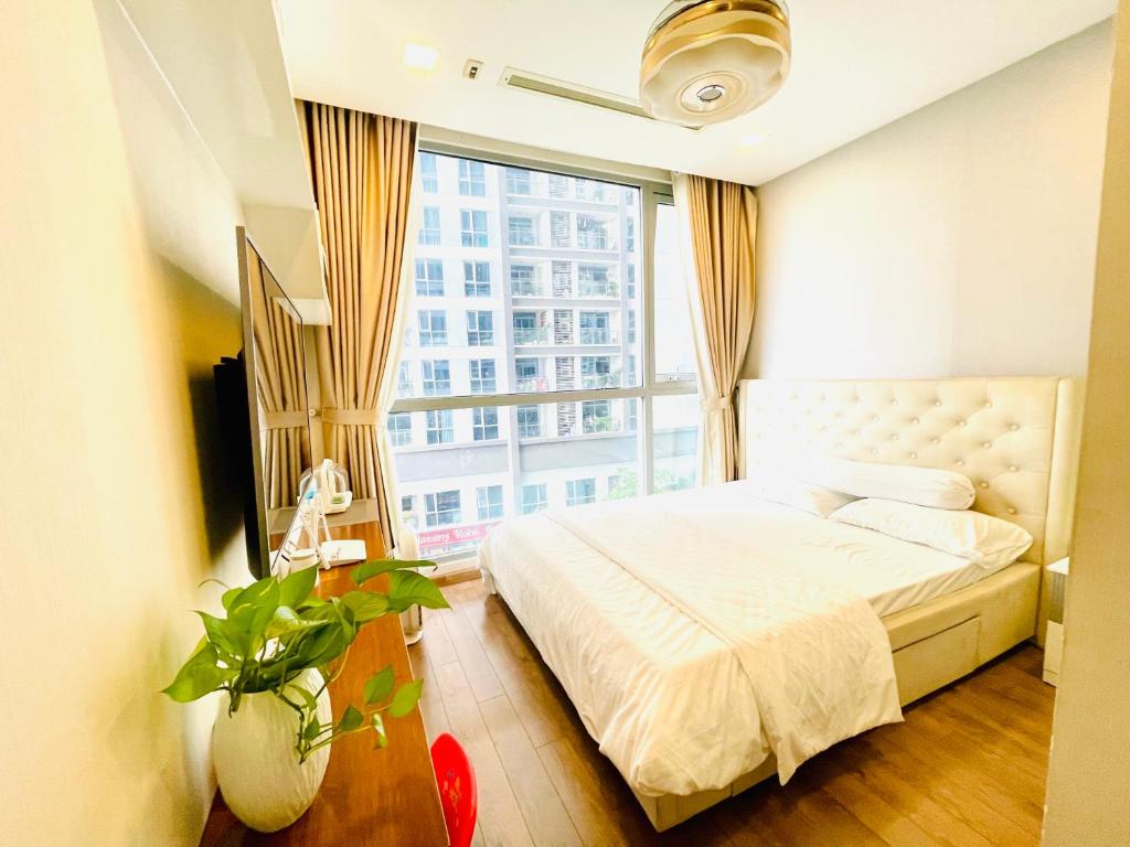 une chambre avec un lit et une grande fenêtre dans l'établissement Hana homestay- 1 Phòng ngủ trong căn hộ chủ nhà đang ở tại Park 4-Vinhome Central Park Tân cảng Bình Thạnh HCM- sát landmark 81, à Hô-Chi-Minh-Ville