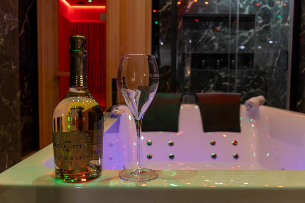 a bottle of wine and a glass on a table at Dea Suite in Bagheria
