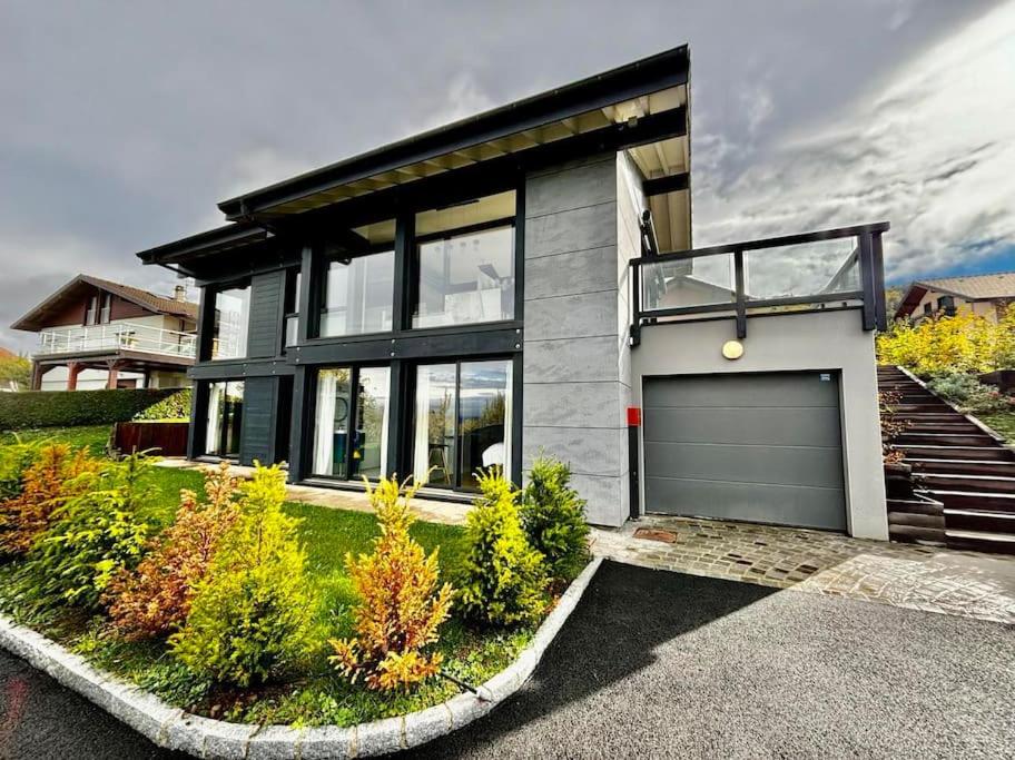 une grande maison avec un garage en face dans l'établissement Magnifique Villa Vue Lac, à Évian-les-Bains