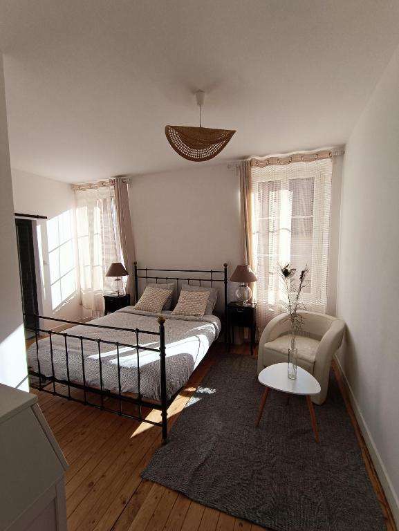 une chambre avec un lit, un canapé et une table dans l'établissement Chambres cosy au coeur du village, à Chaumont-en-Vexin
