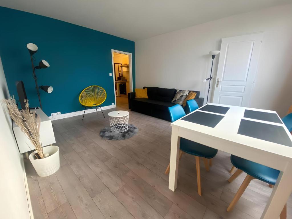 un salon avec une table et un canapé dans l'établissement Berlioz Appartement spacieux et lumineux 