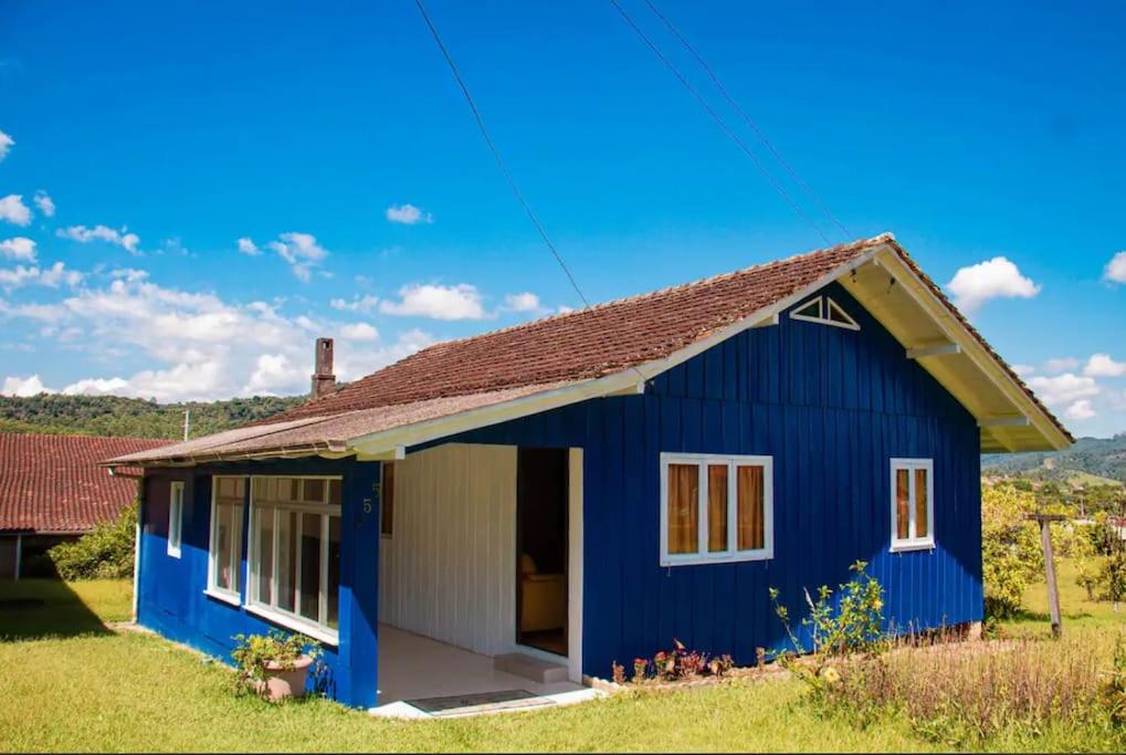 a blue house with a red roof at Casa Lar Azul in Rio Forcação