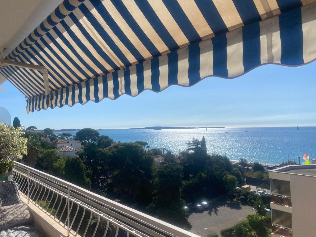 - un balcon avec un parasol offrant une vue sur l'océan dans l'établissement Face mer cannes, à Cannes