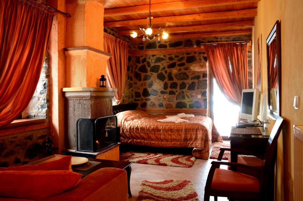 a bedroom with a bed and a tv in a room at To Spitiko in Palaios Agios Athanasios