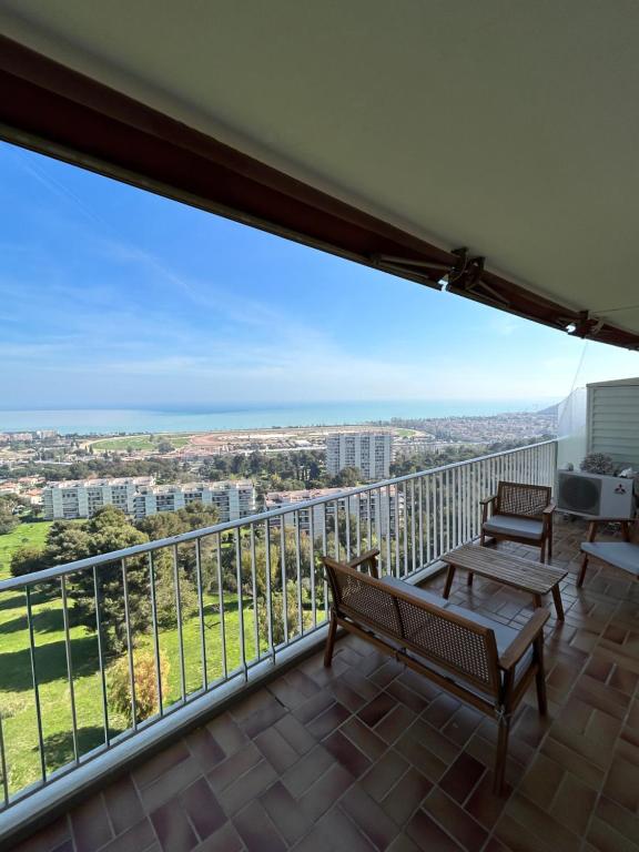 d'un balcon avec bancs et vue sur la ville. dans l'établissement Somptueux appartement vue mer !, à Cagnes-sur-Mer
