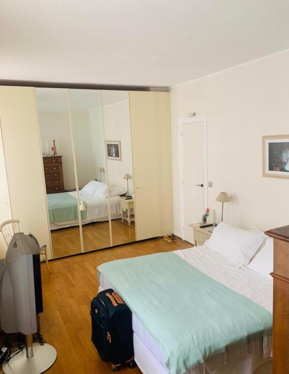 une chambre avec un lit et un grand miroir dans l'établissement Lux Apartment Marais Temple, à Paris