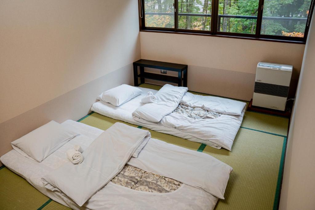 Postel nebo postele na pokoji v ubytování 雪花菜山荘