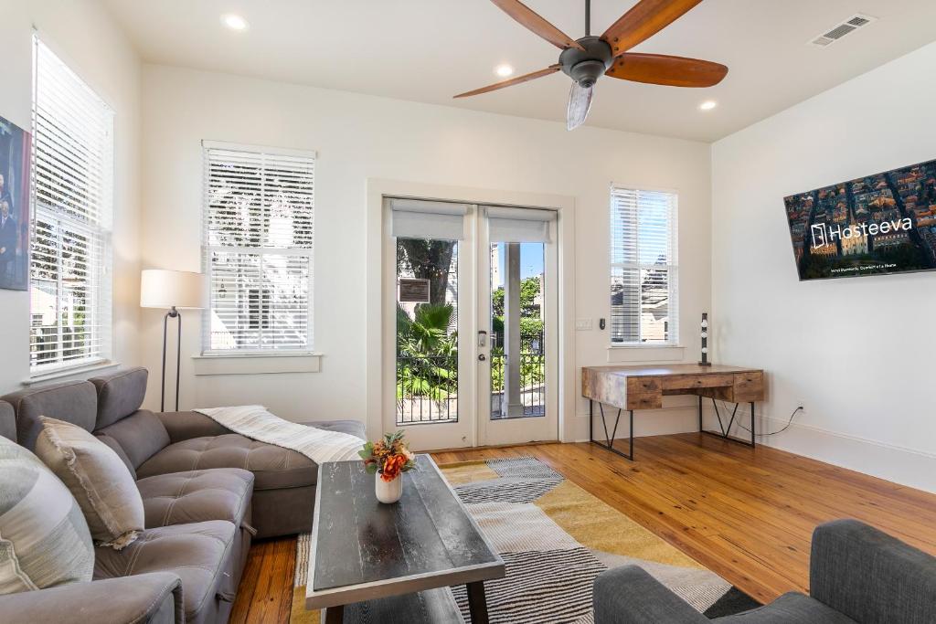 Una sala de estar con un sofá y un ventilador de techo. en Amazing 3BR Cottage off St Charles with Pool, en Nueva Orleans