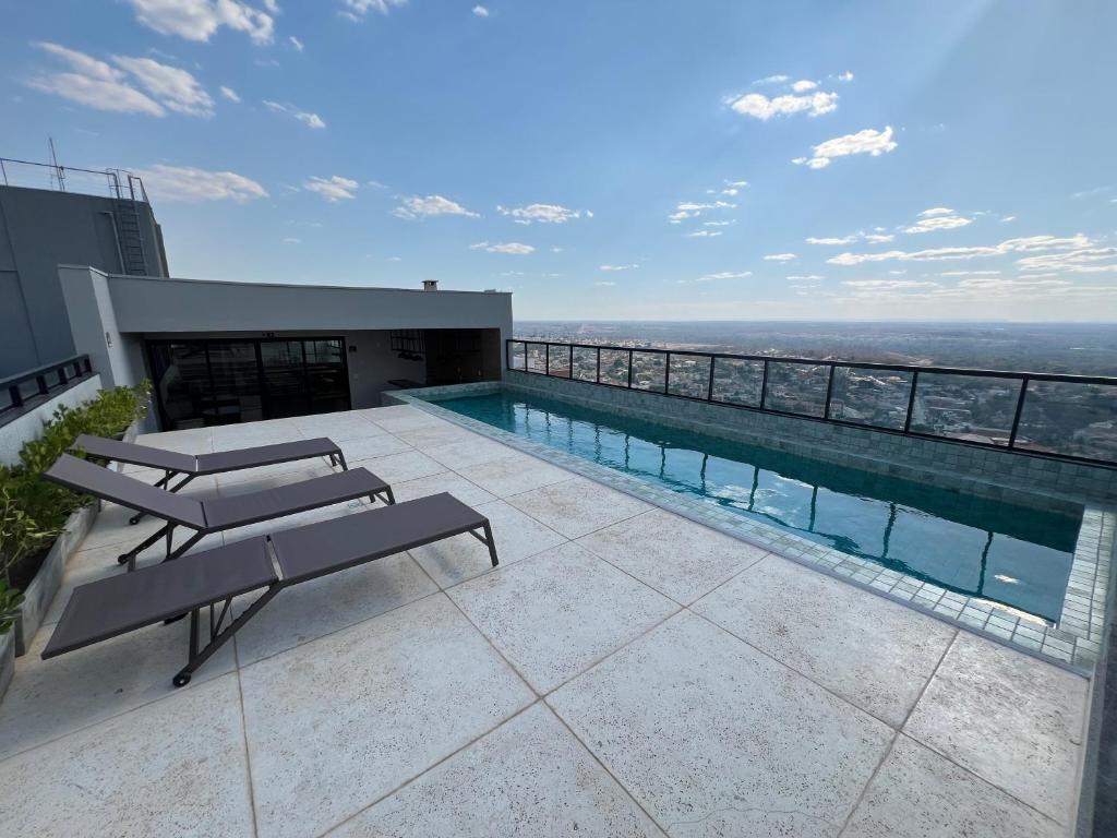 a swimming pool on the roof of a building at Gasparetour Flat - em frente ao Shopping Estação in Cuiabá