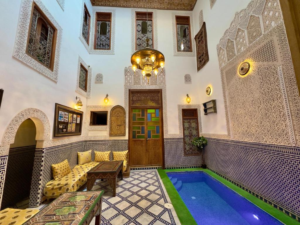 a home with a swimming pool in the middle of a building at Dar Elinor in Fès
