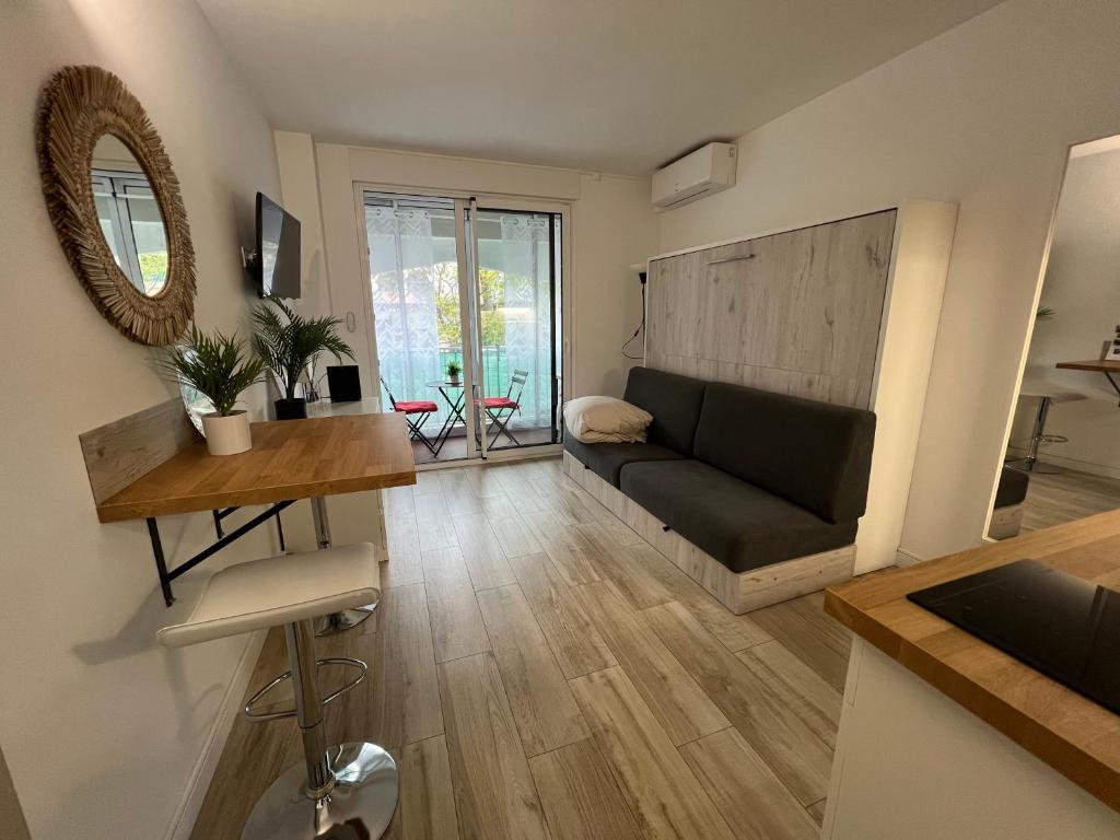 a living room with a couch and a table at Studio Wood Bay in La Grande-Motte