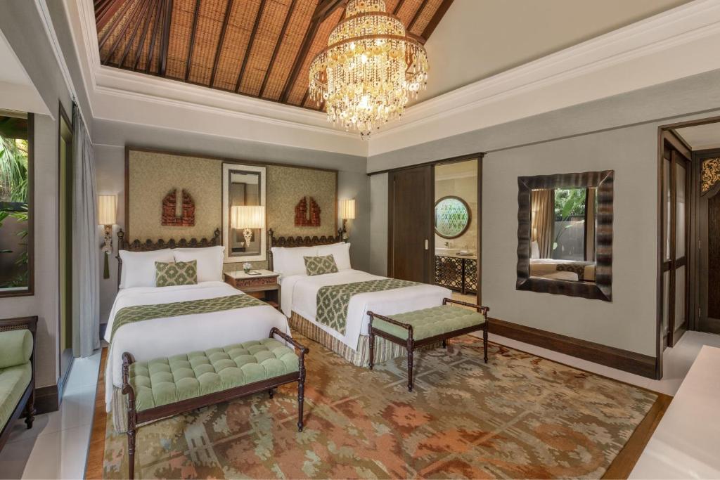a bedroom with two beds and a chandelier at The St. Regis Bali Resort in Nusa Dua