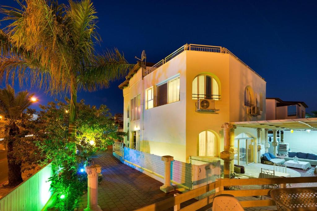 a house with a palm tree in front of it at Villa Li Eilat in Eilat