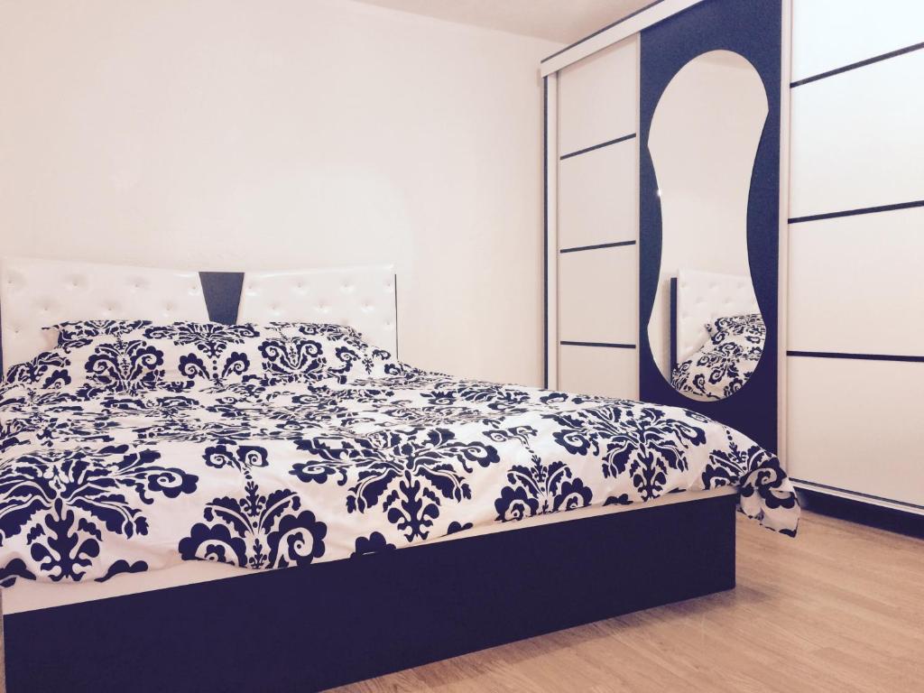 a bedroom with a black and white bed and a dresser at Taf's Small House in Pristina
