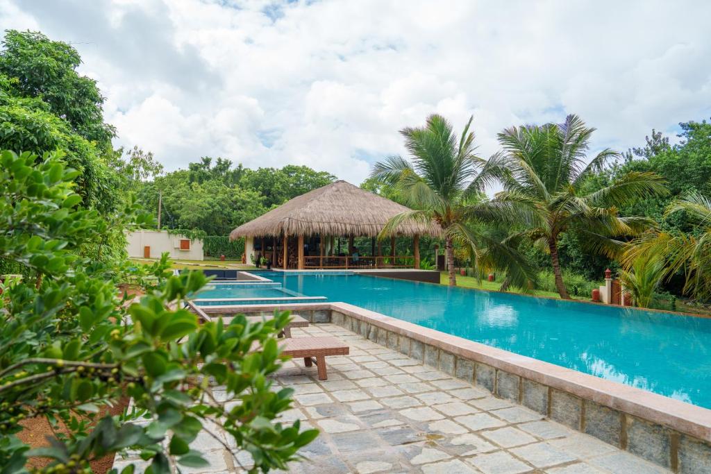 una piscina in un resort con panchina e gazebo di Omkara Rekawa a Tangalle