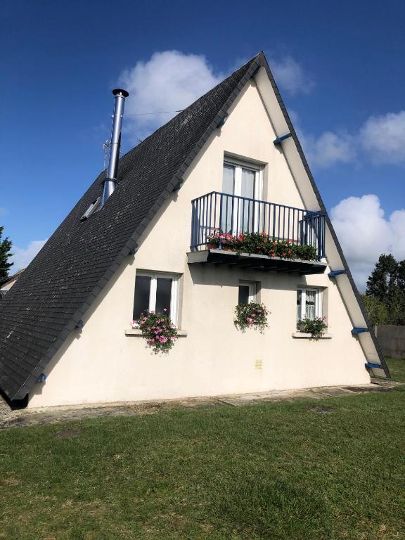 une maison blanche avec des boîtes de fleurs sur les fenêtres dans l'établissement Gîte Les trois pins, à Saint-Germain-sur-Ay