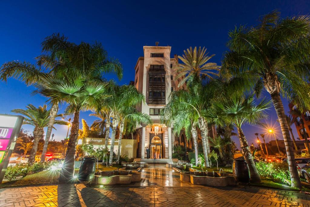 um edifício com palmeiras em frente em Hivernage Hotel & Spa em Marrakech