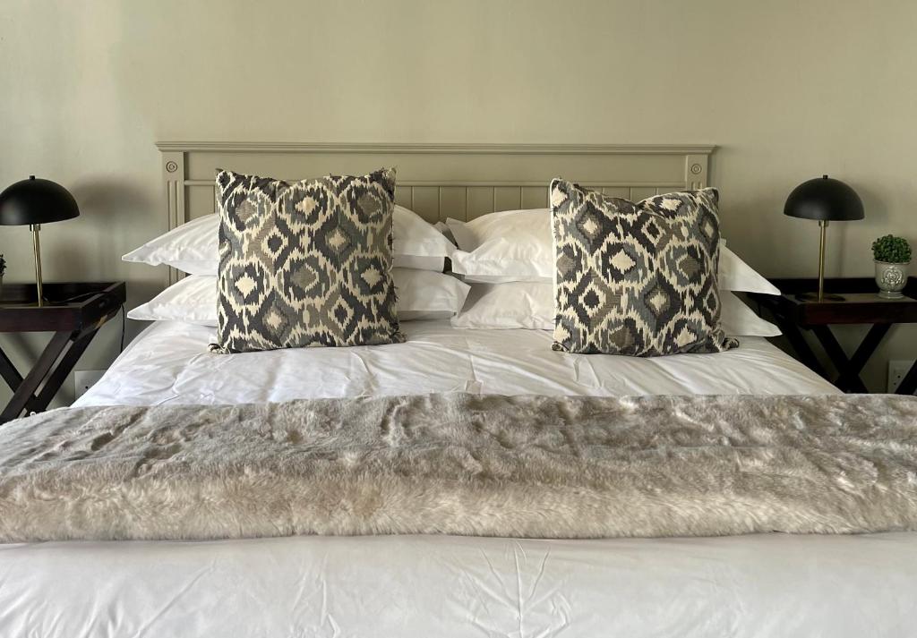 een wit bed met twee kussens erop bij De Gunst Guest Farm in Malmesbury