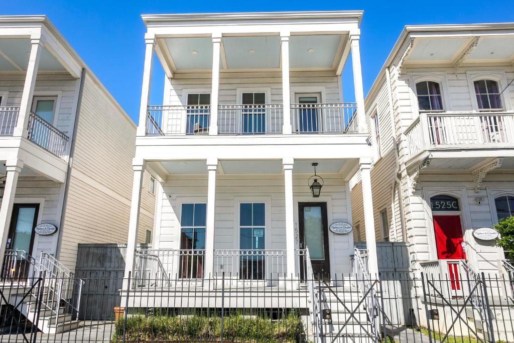 a white house with white columns and balconies at Private 3BR on Carondelet by Hosteeva in New Orleans