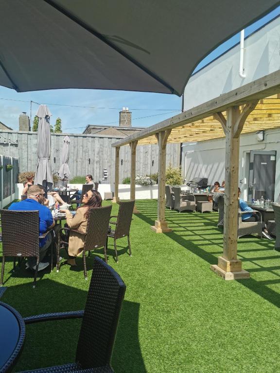 a group of people sitting in chairs under an umbrella at Baginbun Lodge in Fethard on Sea