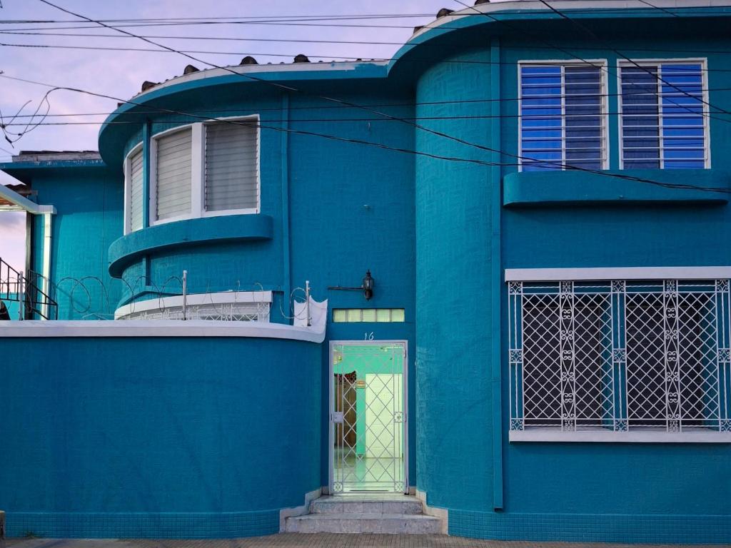 a blue building with a door in front of it at Hostal primaveras nest centro santa ana in Santa Ana