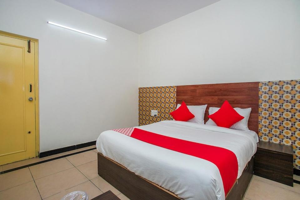 a bedroom with a large bed with red pillows at Royal Guest inn HSR Layout in Bangalore