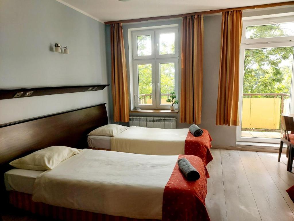 pokój hotelowy z 2 łóżkami i 2 oknami w obiekcie GLIWICKA 16 w mieście Katowice