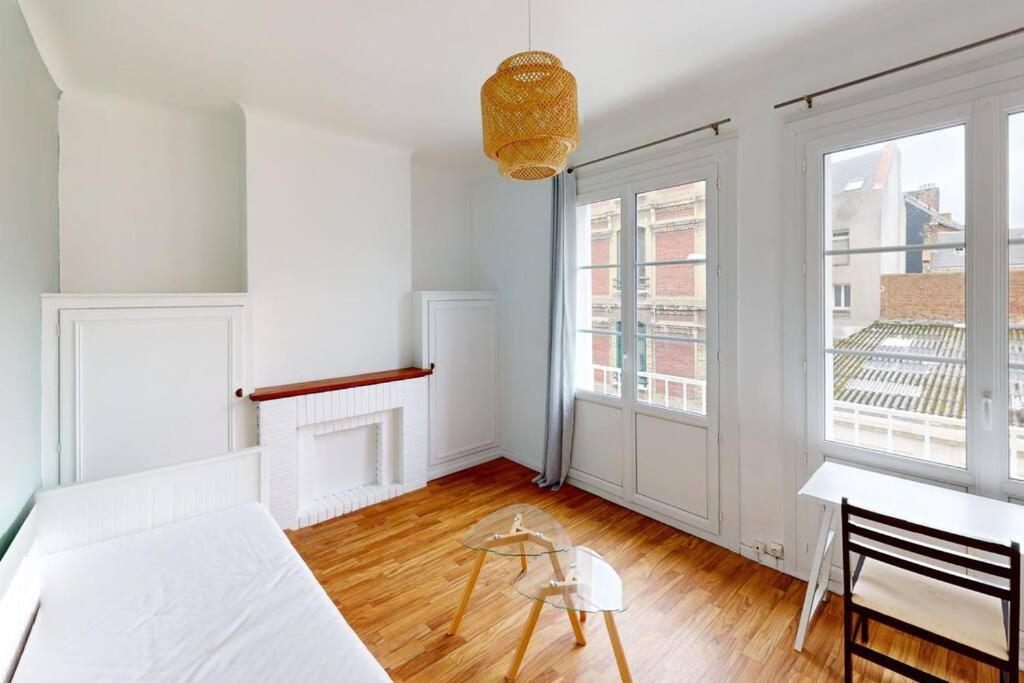a white living room with a table and a window at Studio cozy in Le Havre