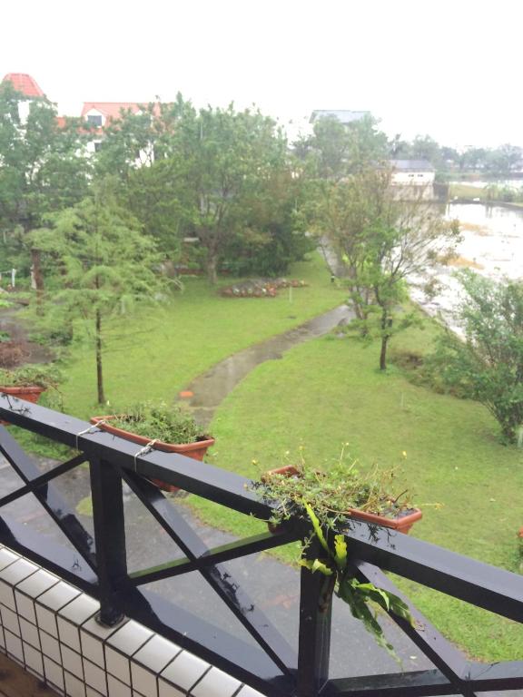 a balcony with two potted plants and a park at Maple in Wujie