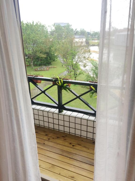 a view of a balcony from a window with a plant at Maple in Wujie