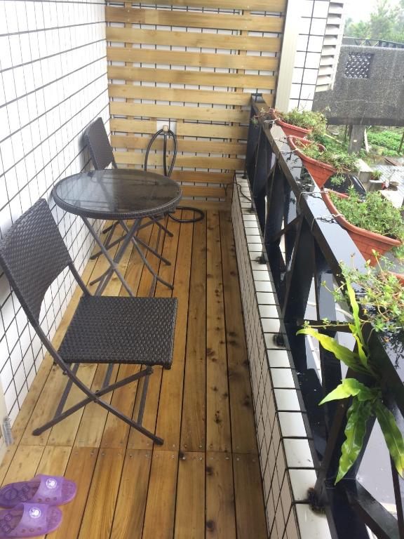 a patio with a table and chairs on a balcony at Maple in Wujie