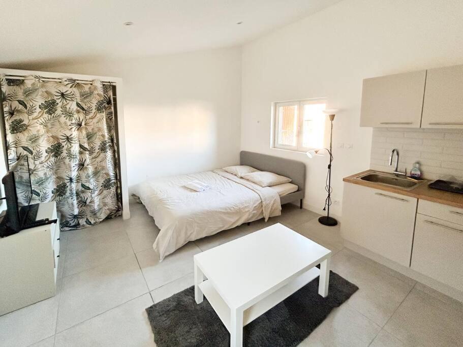 Cette chambre blanche comprend un lit et une table. dans l'établissement Bazille, gare Saint Roch, à Montpellier