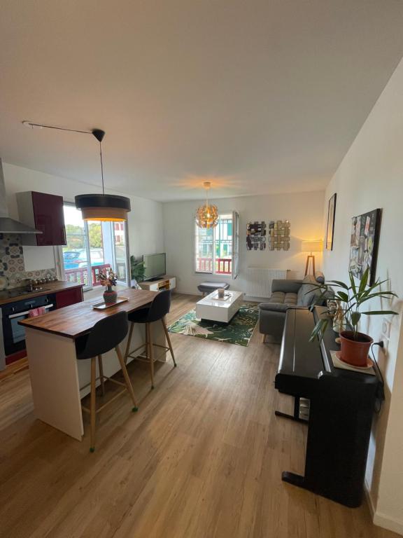 ein Wohnzimmer mit einer Küche und ein Wohnzimmer mit einem Tisch in der Unterkunft charmant appartement in Larressore