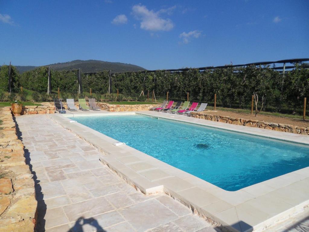 a large swimming pool with lounge chairs at Les Jardins de Bouteille in Manosque