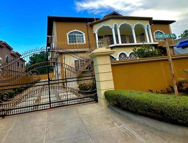 a house with a gate in front of it at White House by White River in Ocho Rios