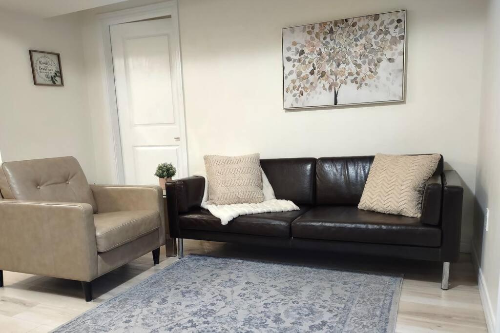 a living room with a leather couch and a chair at Basement Waterloo Near 24-7 Restraints in Waterloo