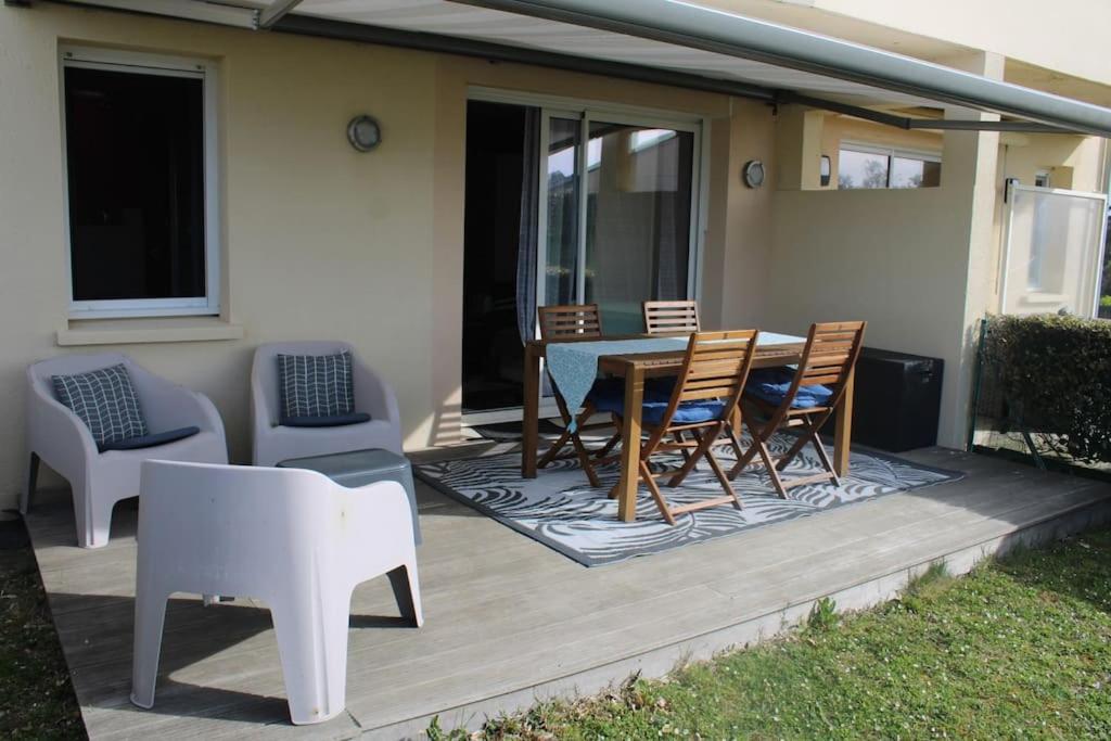 une terrasse avec une table et des chaises sur une maison dans l'établissement instant de rêve entre dune et mer, à Saint-Jean-de-la-Rivière