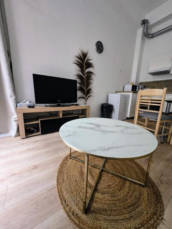 un salon avec une table et une télévision dans l'établissement L'appart Rouennais, à Rouen