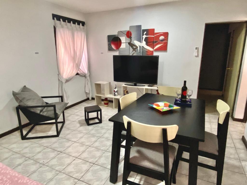 a living room with a table and chairs and a television at Espacio Seven Mendoza in Guaymallen