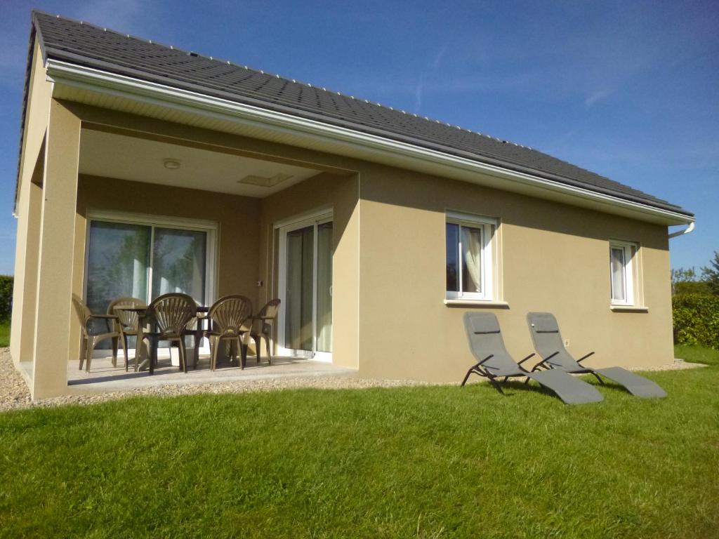 une maison avec un patio avec des chaises et une table dans l'établissement maison les lilas, à La Trivale