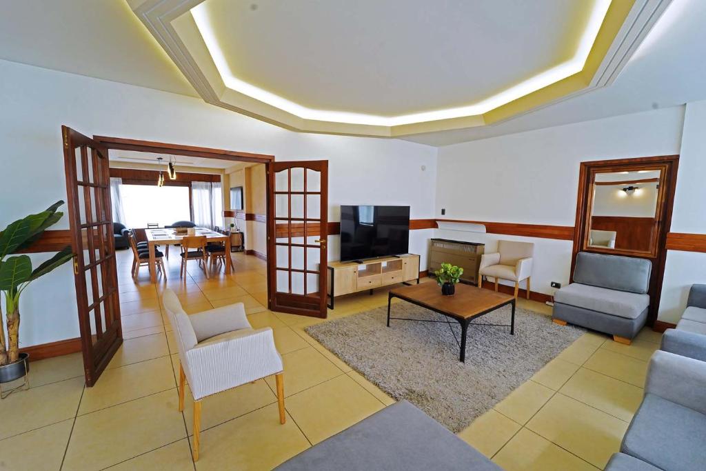 Una sala de estar con un sofá y un televisor. en Departamento 4 dormitorios - Roca 1, en Ushuaia