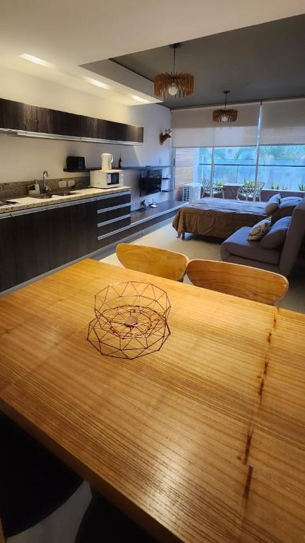 a kitchen with a wooden table and a living room at Alma solar in Federación