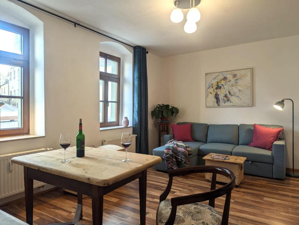 a living room with a couch and a table with wine glasses at Vintage-Wohnung Silberstadt in Freiberg