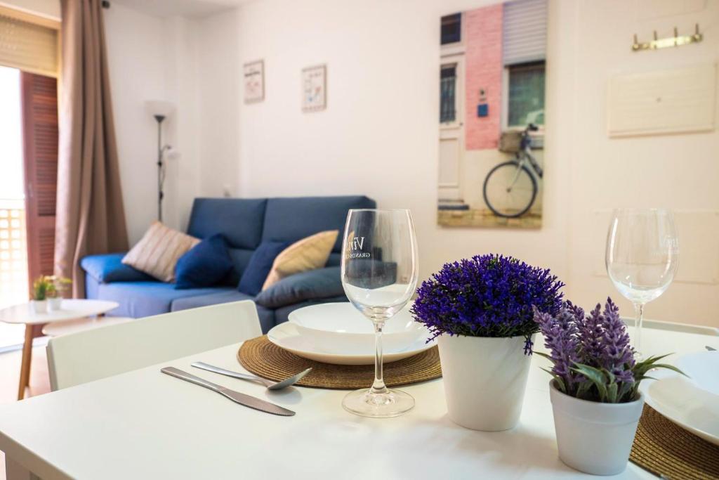 贝尼多姆Apartamento Buen Camino的餐桌,配有两杯酒和紫色鲜花