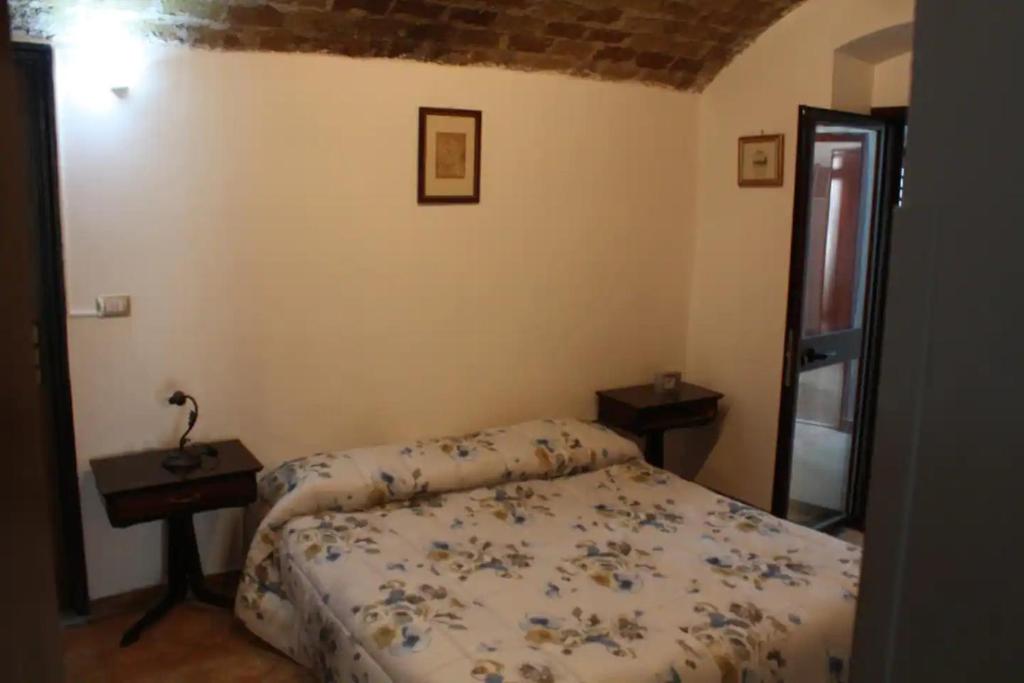 Un pequeño dormitorio con una cama y una mesa. en Mare Azzurro, en Locri