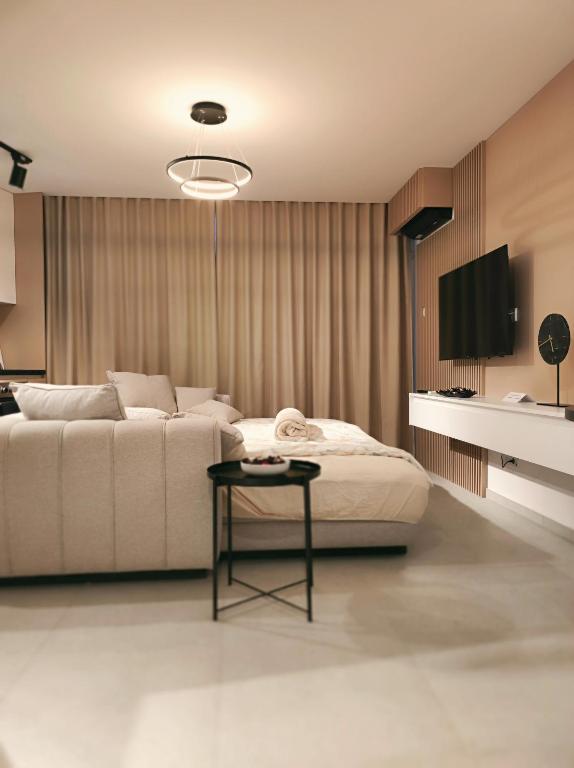 a bedroom with a white bed and a table at Deluxe Rezidencija Bijeljina in Bijeljina