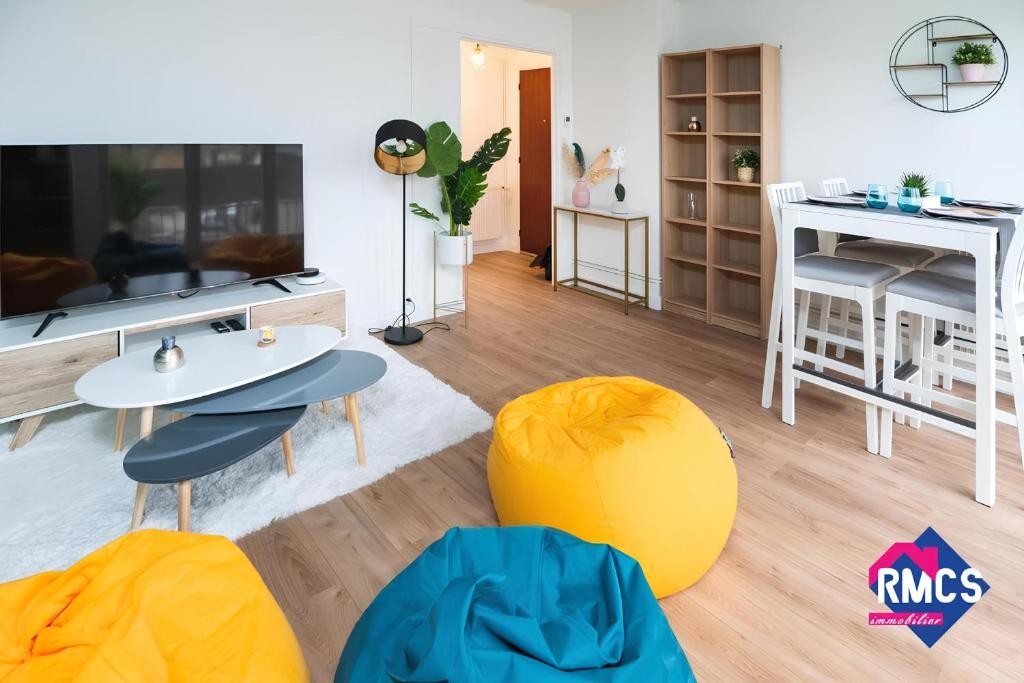 un salon avec des chaises jaunes et bleues et une table dans l'établissement Île Lacroix Appart spacieux et lumineux Rouen 