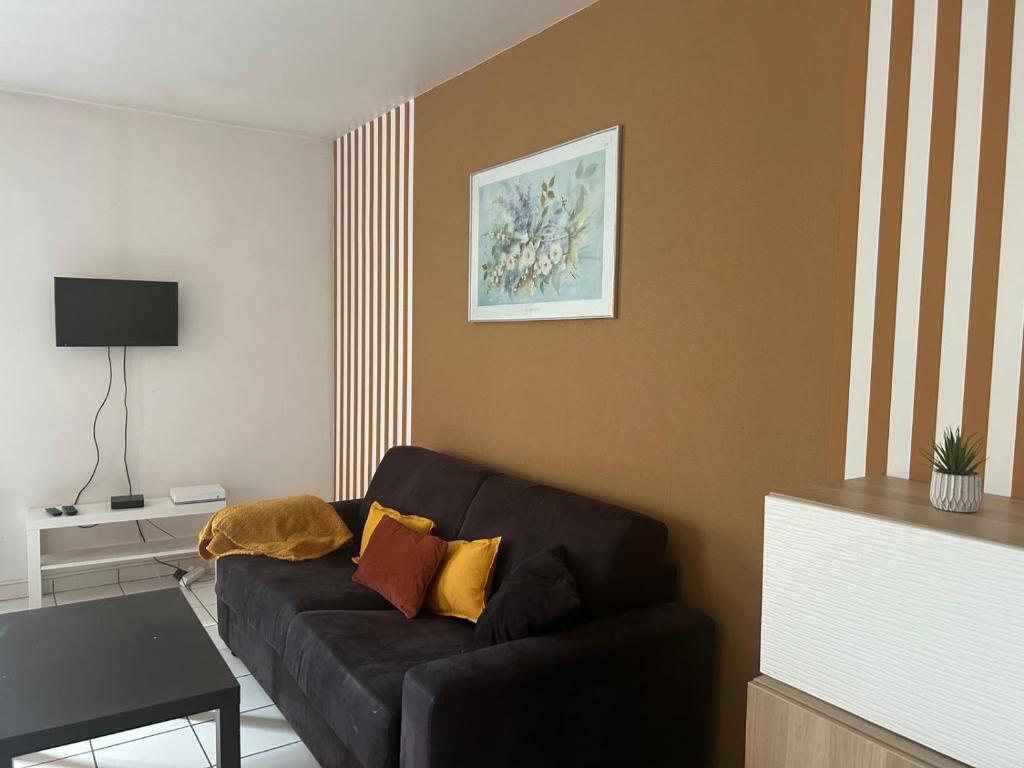 un salon avec un canapé noir dans une pièce dans l'établissement PARIS/DISNEY 50m2 - 10min de Disney - L'Aviateur, à Bussy-Saint-Georges