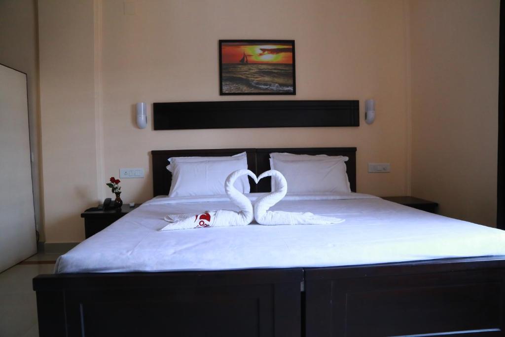 two swans shaped like hearts are on a bed at Orison Residency Hotel in Kunnamkulam