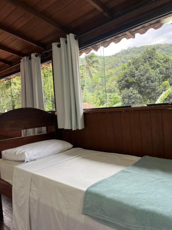 ein Schlafzimmer mit zwei Betten und einem großen Fenster in der Unterkunft Biergarten Hostel in Abraão